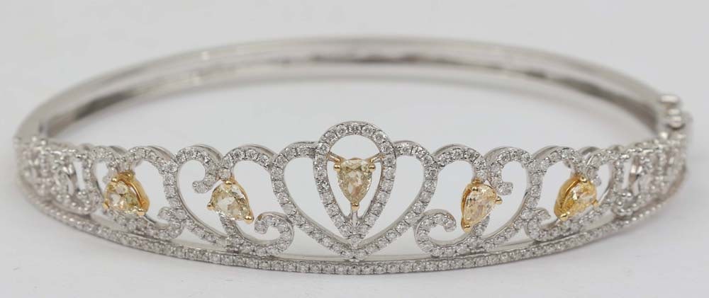 18K YELLOW DIAMOND BANGLE TIARA MOTIF: 18K White and Yellow Gold Bangle Featuring Pear Yellow Diamonds and Round White Diamonds in Tiara motif. Two hundred and eleven brilliant round diamonds totaling 1.10 ct. Five fancy yellow diamonds to