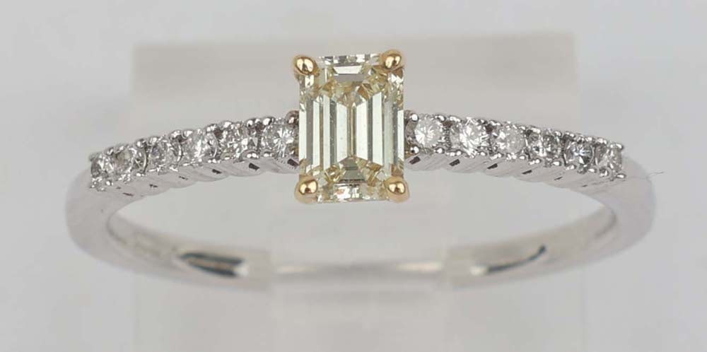 18K YELLOW DIAMOND PROMISE RING MICHAEL CHRISTOFF: Michael Christoff 14K White Gold Ring Featuring a Yellow Diamond and White Diamonds on band. Fancy yellow diamond emerald cut .32 ct with .21 ct diamond accents. Size: 6.25 Weight: 1.9 G Must be paid