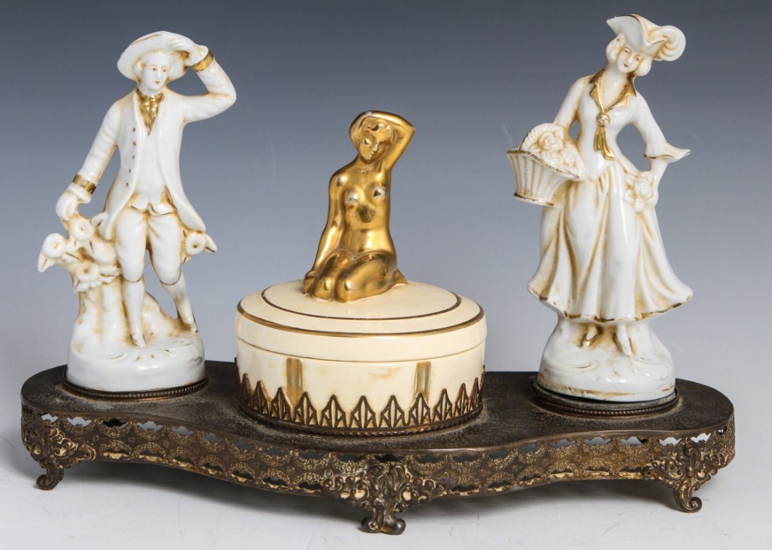 EARLY NORITAKE DRESSER SET: EARLY NORITAKE DRESSER SET Dresser set has two colonial dressed porcelain figures that stand 6" and are stamped at the bottom with a crown and M signifying their production around early 20th century. 