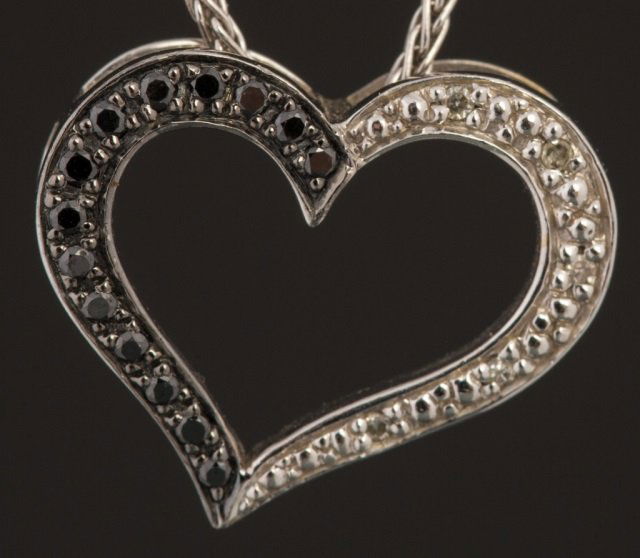 WHITE GOLD BLACK AND WHITE DIAMOND HEART PENDANT: WHITE GOLD BLACK AND WHITE DIAMOND HEART PENDANT Ladies 10K white gold heart pendant, with white and black diamonds. Pendant comes on a 20in,14K white gold chain. Weight: 4.3 g Size: 20in