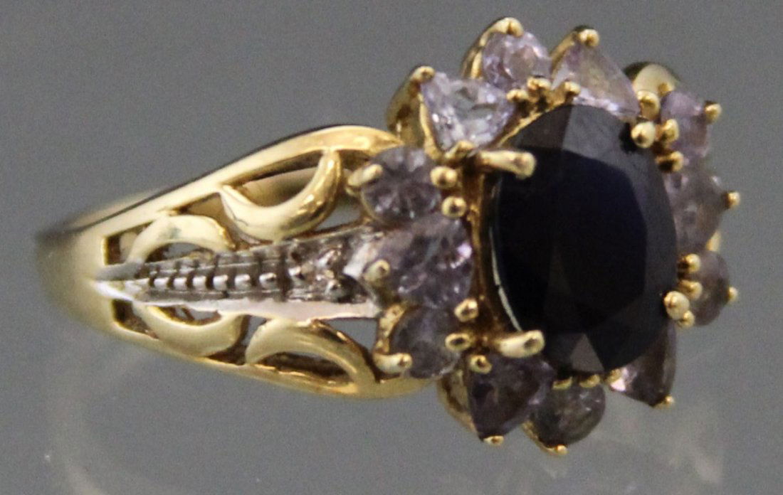 LADIES 14K YELLOW GOLD SPINEL FASHION RING: LADIES 14K YELLOW GOLD SPINEL FASHION RING Ladies 14K yellow gold ring with oval center Spinel stone, approximately 1 ct, surrounded by 6 trillion cut and 6 round purple stones, with white gold side a