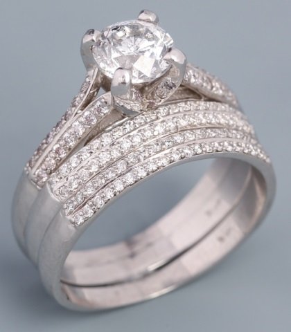 14K WHITE GOLD THREE RING DIAMOND WEDDING SET: 14K WHITE GOLD THREE RING DIAMOND WEDDING SET 14K white gold three ring diamond wedding set. Center stone is .95 ct with F, I1 carity clarity. Solitaire setting in the center ring is four prong, accom