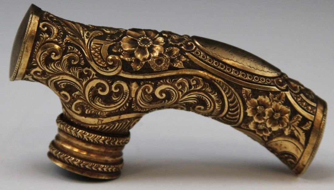 GOLD TONE REPOUSSE FLORAL PRESENTATION CANE HANDLE: GOLD TONE REPOUSSE FLORAL CANE HANDLE Gold tone metal and plaster filled presentation cane handle with repousse floral design and personalized inscription that reads "To Cheif Portfield from his frien