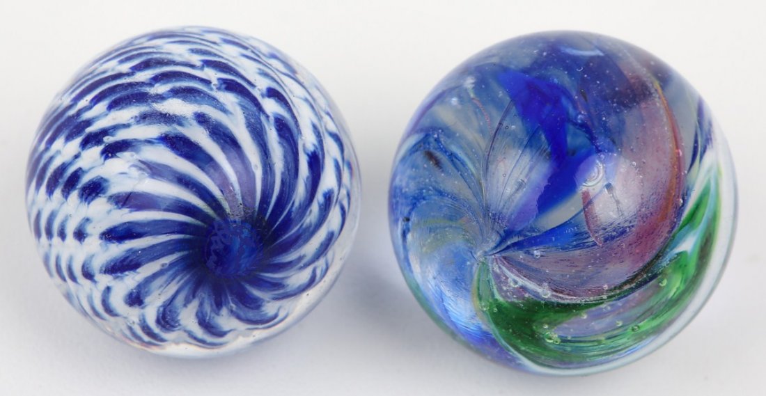 LOT OF TWO SIGNED GLASS JIM DAVIS MARBLES: LOT OF TWO SIGNED GLASS JIM DAVIS MARBLES Jim Davis signed marbles 1. Blue and white corkscrew 37mm. 2. Rainbow swirl 38.5mm.