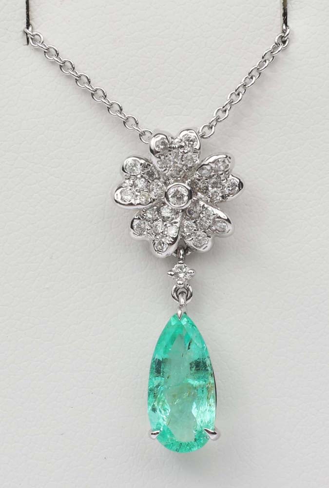 14K WHITE GOLD EMERALD & DIAMOND PENDANT FLORAL: 14k white gold pear emerald with diamond floral pendant. Designer Michael Christoff. Gemstones: Emerald & Diamond 32 round diamonds .24 ct.One Emerald Columbian 1.32 ct. 14K white gold. Length:16"