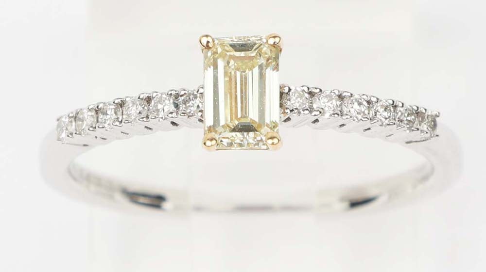 18K WHITE GOLD FANCY YELLOW DIAMOND RING: 18k white and yellow gold fancy yellow diamond ring. Designer Michael Christoff. Gemstones: Fancy Yellow & white diamonds 12 round diamonds .12ctOne fancy yellow diamond .40 ct. 18K white gold. Size: