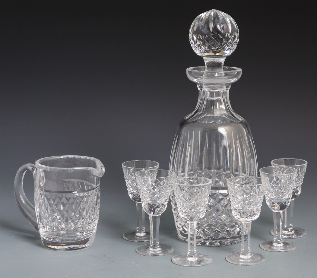 LOT OF EIGHT WATERFORD CRYSTAL PIECES: LOT OF EIGHT WATERFORD CRYSTAL PIECES Lot of eight Waterford Crystal pieces, six stemware shot glasses, a cream pitcher and a decanter. Overall good condition with mark on bottom. Size: 4", 4" , 11"