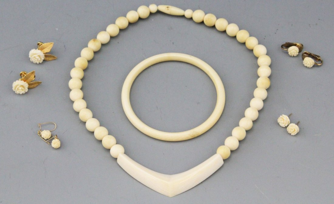 MIXED LOT OF LADIES IVORY JEWELRY: MIXED LOT OF LADIES IVORY JEWELRY Mixed lot of ivory jewelry including a polished beaded ivory necklace with large triangular pectoral pendant, polished ivory bangle, and four pairs of floral motif ea