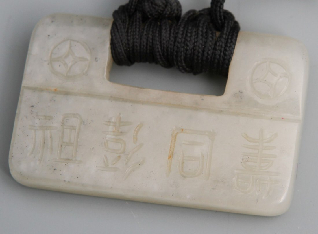 ANTIQUE WHITE MUTTON CREAM JADE LOCKET PENDANT: ANTIQUE WHITE MUTTON CREAM JADE LOCKET PENDANT Antique Chinese white jade lock pendant on black string. Pendant is carved with the saying "Have longevity like Pengstu's," and "Have blessings like Han 