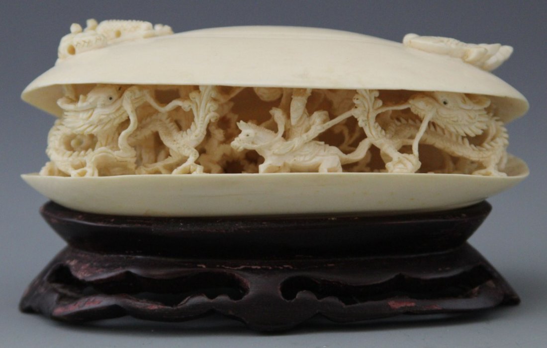 JAPANESE IVORY CARVED OKIMONO CLAM'S DREAM: JAPANESE IVORY CARVED OKIMONO CLAM'S DREAM Large Japanese carved ivory okimono of a Clam's Dream, depicting an ornately carved illusionary scene of a man on horseback battling a pair of dragons, sever