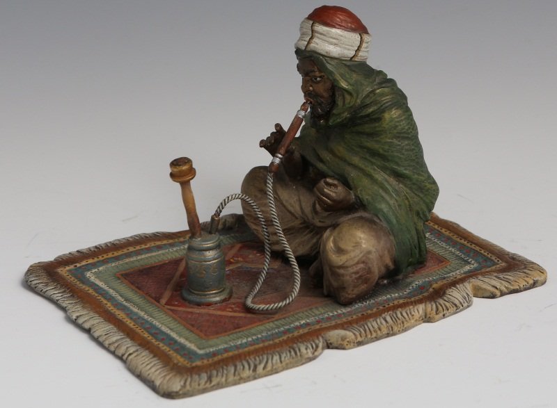 BERGMAN COLD-PAINTED BRONZE MAN WITH HOOKAH: BERGMAN COLD-PAINTED BRONZE MAN WITH HOOKAH Franz Xavier Bergman (Austrian, 1861-1936), cold-painted bronze figure of man with hookah pipe seated on oriental rug. Hallmarked on the man's rear - with a
