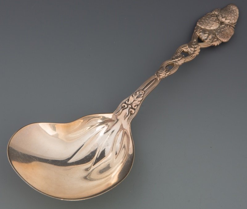 TIFFANY & CO STERLING STRAWBERRY CASSEROLE SPOON: TIFFANY & CO STERLING STRAWBERRY CASSEROLE SPOON Tiffany & Co sterling silver berry casserole spoon. Strawberry pattern with kidney shaped bowl and pierced handle. Weight 124g Size: 9.5" Condition: Ve