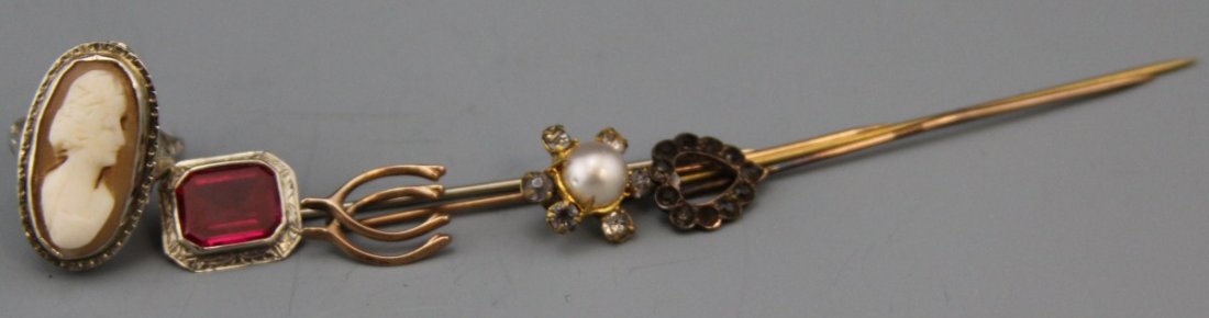 (3) VINTAGE HAT PINS & FILIGREE CAMEO RING 10K: (3) VINTAGE HAT PINS & FILIGREE CAMEO RING 10K Three 10K gold hat pins: heart shaped with rhinestone accent, double wishbone, and emerald cut ruby in etched setting. Size 4 cameo ring in 10K white gol