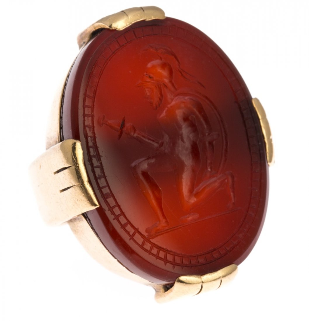 MENS 14K YELLOW GOLD CARNELIAN INTAGLIO RING: MENS 14K YELLOW GOLD CARNELIAN INTAGLIO RING A men's 14K yellow gold ring with a large oval carnelian stone with carving of a soldier. Weight: 17.7g Size: 5.5 Condition: Very good with some age wear.