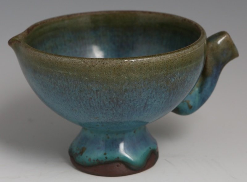CHINESE JUNYAO FOOTED TEA BOWL WITH PHOENIX HANDLE: CHINESE JUNYAO FOOTED TEA BOWL WITH PHOENIX HANDLE Chinese Junyao earthenware footed tea bowl with spout and phoenix handle, blue glaze, Song Dynasty. Size: 2.5" tall, 3.25" diameter