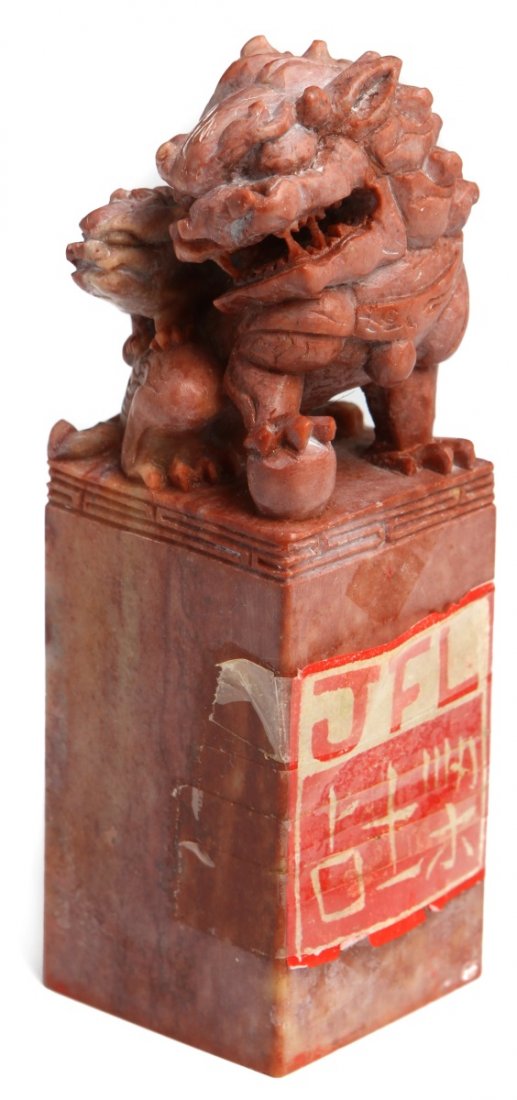CHINESE CARVED SOAPSTONE SEAL WITH FOO DOGS: CHINESE CARVED SOAPSTONE SEAL WITH FOO DOGS Carved red soapstone seal with finial of foo dog and pup. Seal face is carved with the letters "JFL" in both Chinese and English. Weight: 394.6g Size: 5"