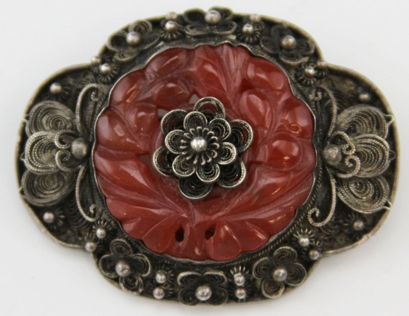 CHINESE SILVER FILIGREE CARNELIAN FLORAL PIN: CHINESE SILVER FILIGREE CARNELIAN FLORAL PIN Oval pin/brooch, floral filigree pattern with carved carnelian stone, marked "Silver China". Weight: 19.2g Size: 1.5 x 2"