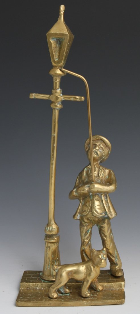 BRASS STATUE OF A MAN LIGHTING A STREET LIGHT: BRASS STATUE OF A MAN LIGHTING A STREET LIGHT A gilded brass statue of a man lighting a street light on a cobblestone and brick street accompanied by his dog. Size: 13"