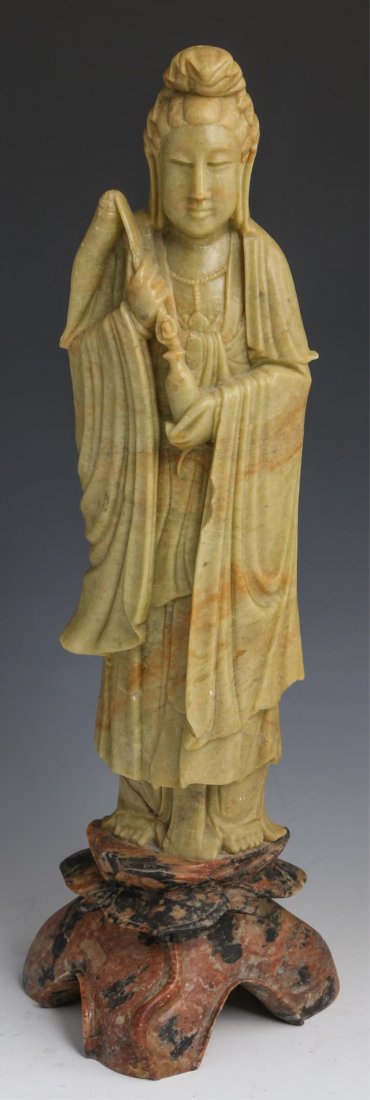 CHINESE SOAPSTONE GUANYIN STATUE: CHINESE SOAPSTONE GUANYIN STATUE Chinese carved soapstone figurine of Guanyin; pea green figure on mottled red and black lotus base. Size: 16"