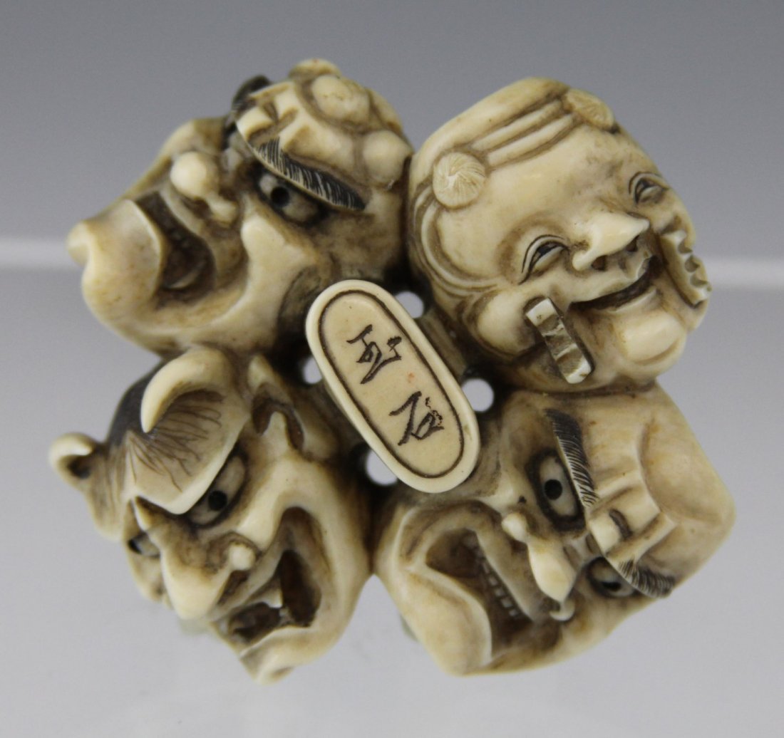 JAPANESE CARVED IVORY NETSUKE FOUR NOH MASKS: JAPANESE CARVED IVORY NETSUKE FOUR NOH MASKS 19th century Japanese carved ivory netsuke featuring four noh masks in a circle, signature to middle. Weight: 33g Size: 2.25 x 2 x .5"