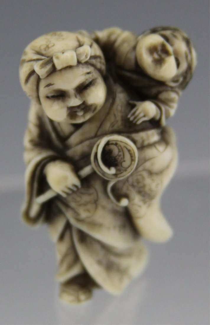 JAPANESE CARVED IVORY NETSUKE MOTHER & CHILD: JAPANESE CARVED IVORY NETSUKE MOTHER & CHILD Mid-20th C. Japanese carved ivory netsuke of a woman carrying a child on her back, early 20th C., signed Kogyoku. Weight: 17.6g Size: 1.5"
