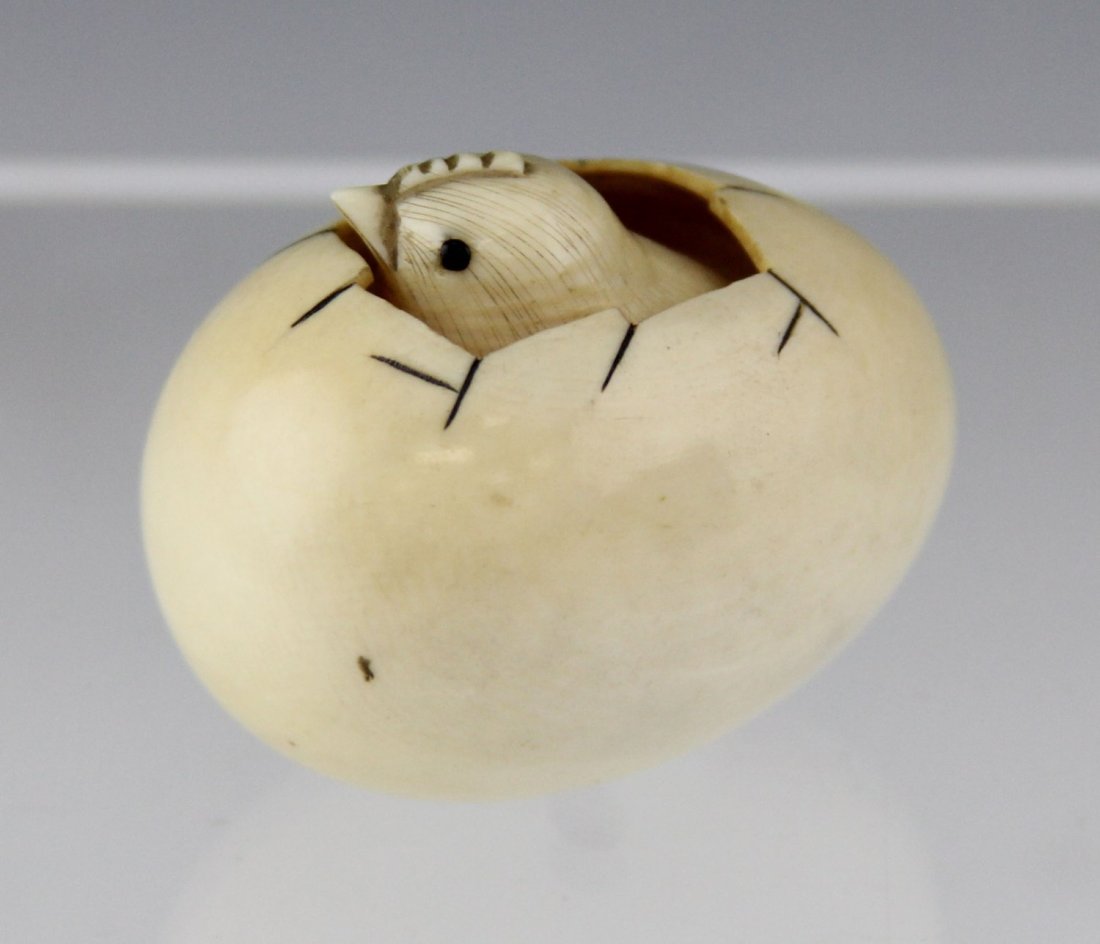 JAPANESE CARVED IVORY HATCHING CHICK NETSUKE: JAPANESE CARVED IVORY HATCHING CHICK NETSUKE Japanese carved ivory netsuke of a chick hatching out of an egg, signed to bottom. Weight: 30g Size: 1.25 x 1.25 x 1.5"