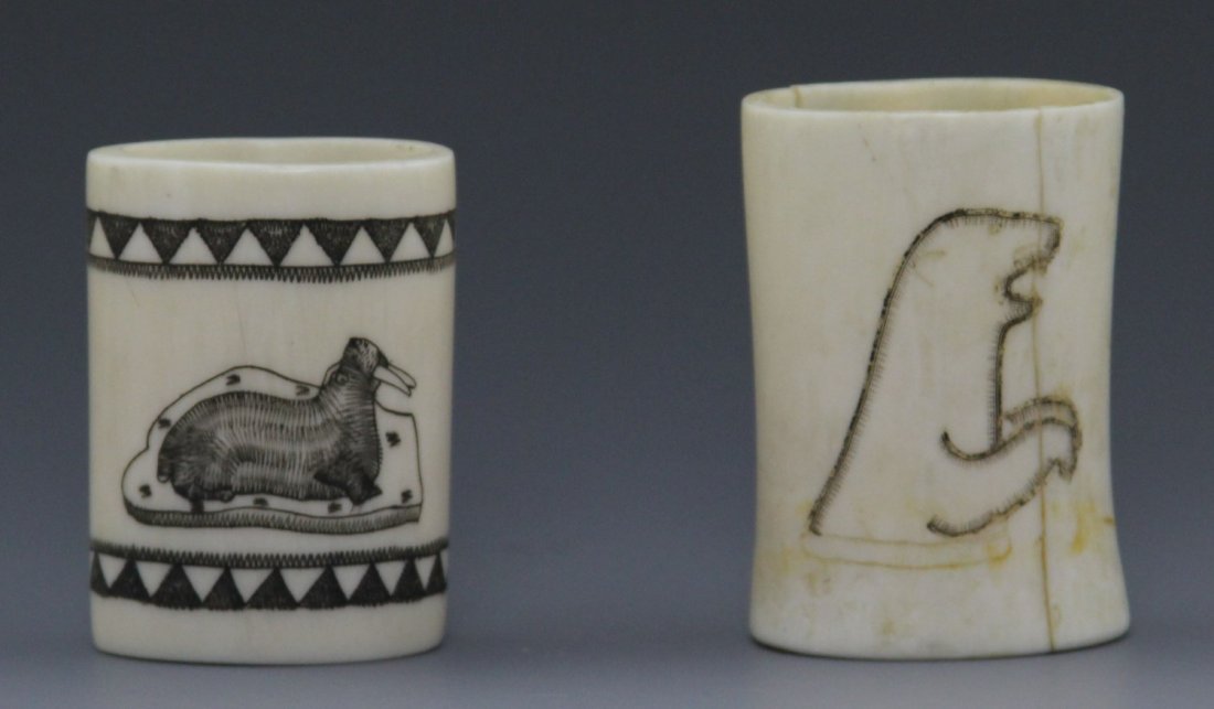 PAIR OF BONE SCRIMSHAW CUPS: PAIR OF BONE SCRIMSHAW CUPS Pair of scrimshaw decorated bone cups, one is decorated with walrus and the other a seal. Weight: 89.1 g Size: 2"
