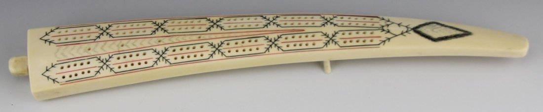 INUIT CARVED IVORY CRIBBAGE BOARD: INUIT CARVED IVORY CRIBBAGE BOARD Carved ivory cribbage board, Inuit, stands on two feet and has plug on side for storing game pegs. Early 20th century. Weight: 438.1g Size: 14"