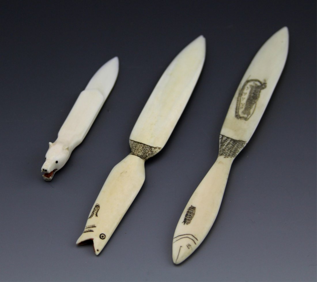 (2) IVORY INUIT LETTER OPENERS WITH MONEY CLIP: (2) IVORY INUIT LETTER OPENERS WITH MONEY CLIP Two carved ivory letter openers, decorated with scrimshaw, handles feature fishes. Also included is a bear head money clip carved from ivory. Weight: 31.