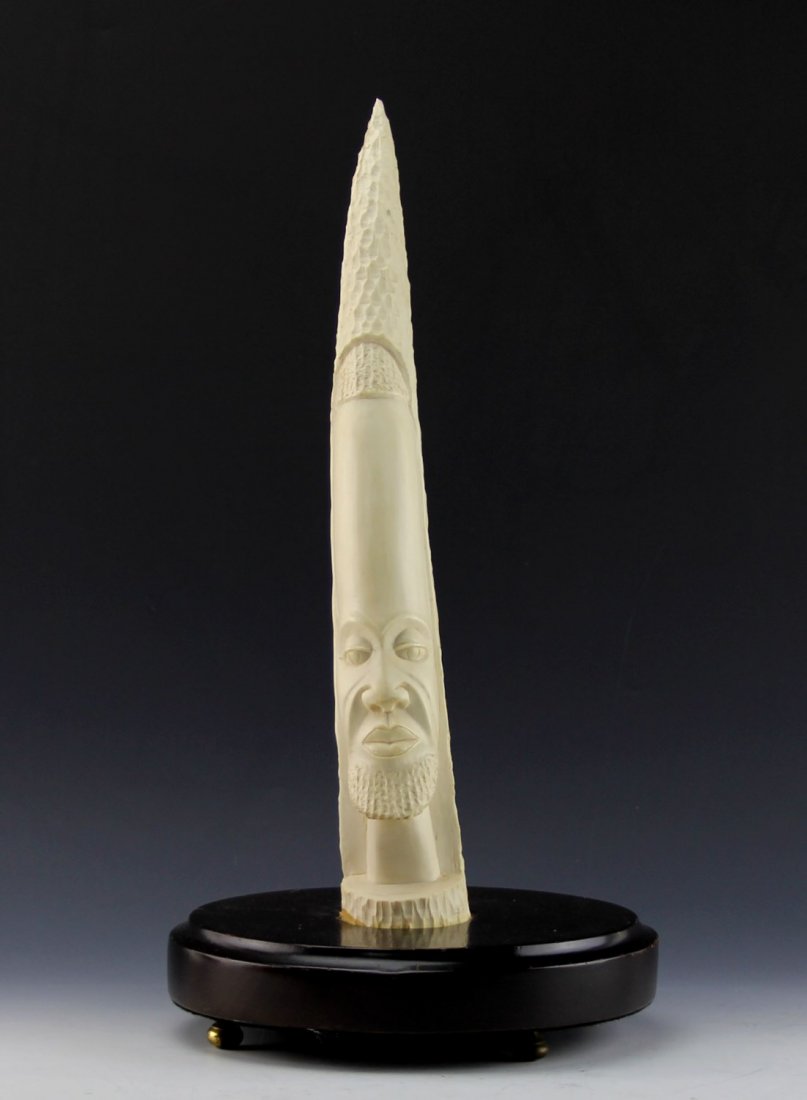 AFRICAN IVORY TRIBAL CARVING ELEPHANT TUSK: AFRICAN IVORY TRIBAL CARVING ELEPHANT TUSK Antique African ivory elephant tusk with figural male face. Attached to wood base. Weight: 4.4 lbs with base Size: 18" with base