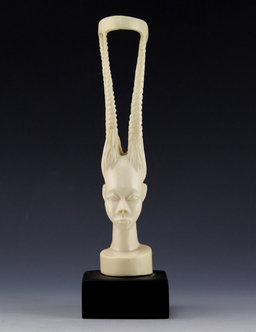 AFRICAN ELEPHANT IVORY TRIBAL QUEEN BUST: AFRICAN ELEPHANT IVORY TRIBAL QUEEN BUST Antique African carved ivory bust, depicts female figure with sculpted hair in four spires. Attached to wood base. Weight: 239.9g with base Size: 8.5" with bas