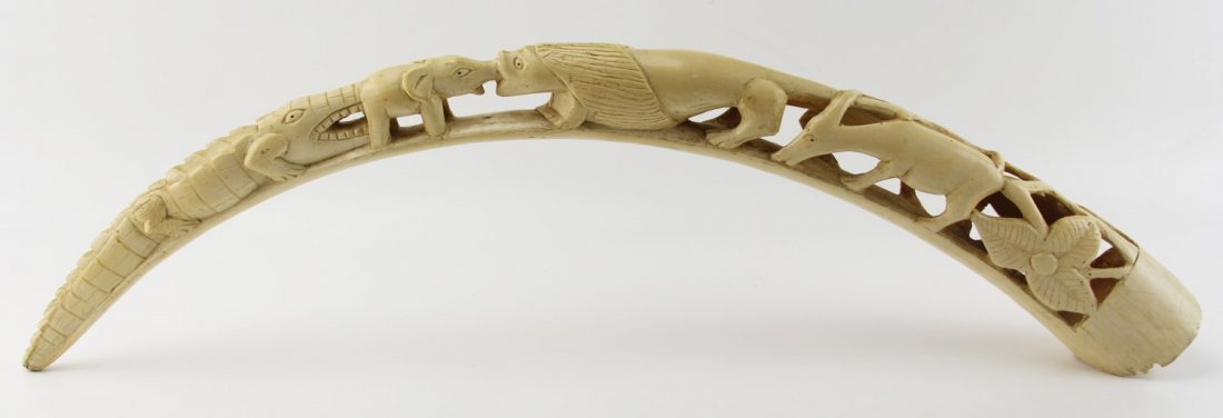 ANTIQUE CARVED AFRICAN IVORY TUSK ZOOMORPHIC: ANTIQUE CARVED AFRICAN IVORY TUSK ZOOMORPHIC Large carved African ivory tusk with zoomorphic motif, with large wooden stand. Weight: 2000 g Size: 38"