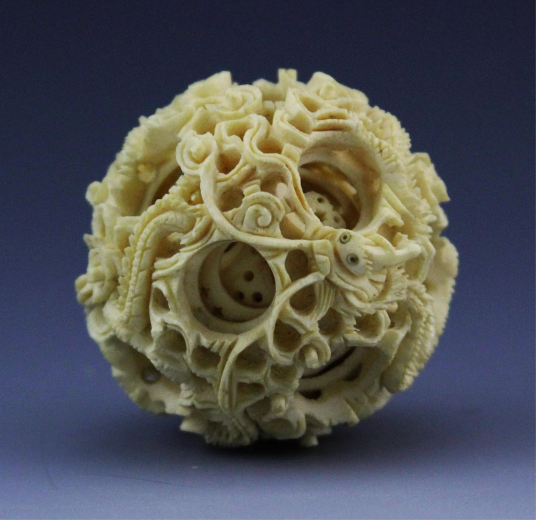 ANTIQUE CHINESE IVORY PUZZLE BALL: ANTIQUE CHINESE IVORY PUZZLE BALL Antique ivory Chinese puzzle ball with multiple layers, dragon motif. Weight: 46.6 g Size: 2" diameter