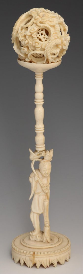 19TH C. IVORY PUZZLE BALL WITH STAND: 19TH C. IVORY PUZZLE BALL WITH STAND 19th century ivory puzzle ball with decorative stand. Stand features a male figure at the base and measures 6.5". Puzzle ball measures 2". From a private Minnesota