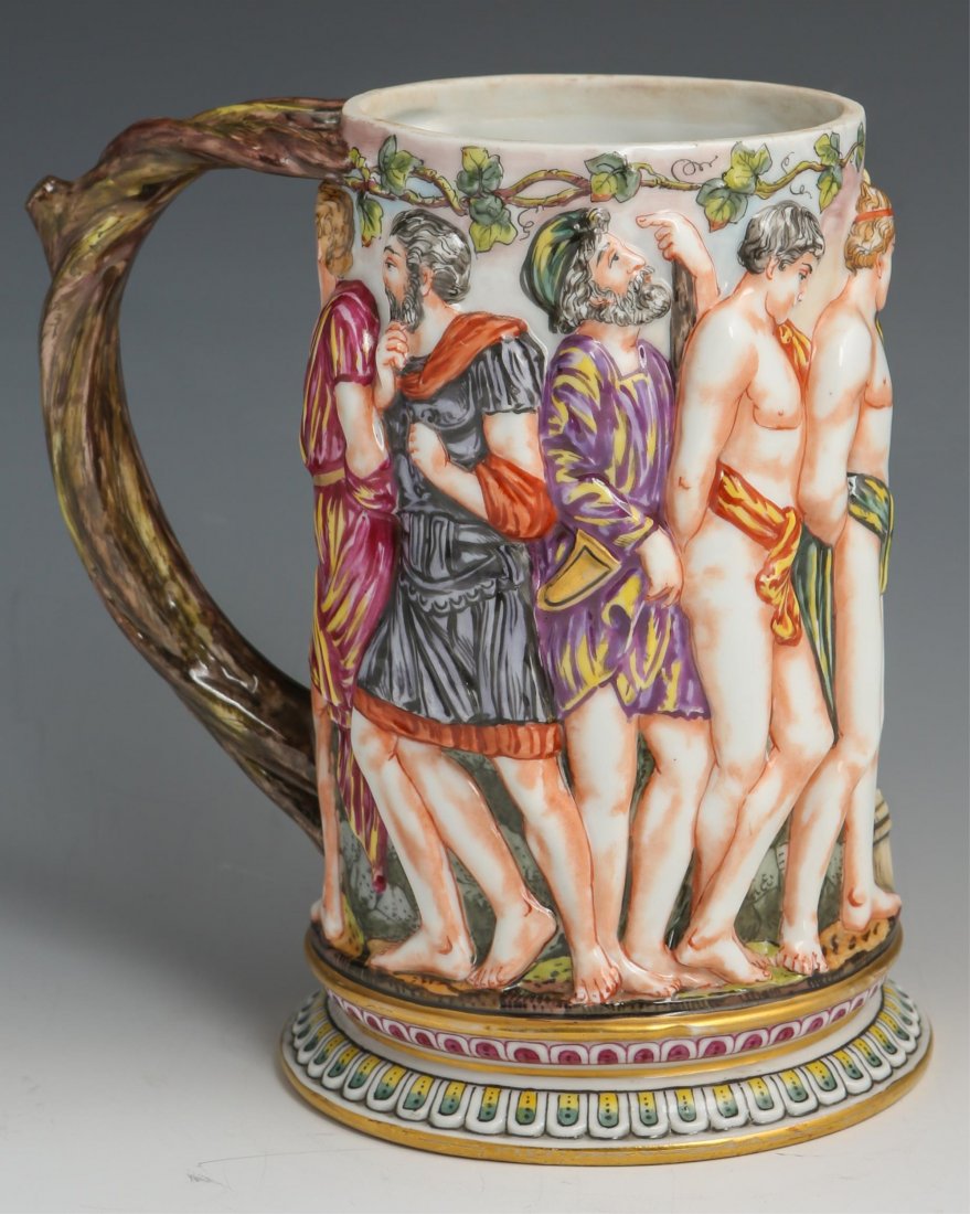 CAPODIMONTE PORCELAIN STEIN TYPE MUG: CAPODIMONTE PORCELAIN STEIN TYPE MUG Capodimonte porcelain stein type mug with classical imagery around the vessel. The handle shaped like a twisting branch. Size: 7 x 4.75"