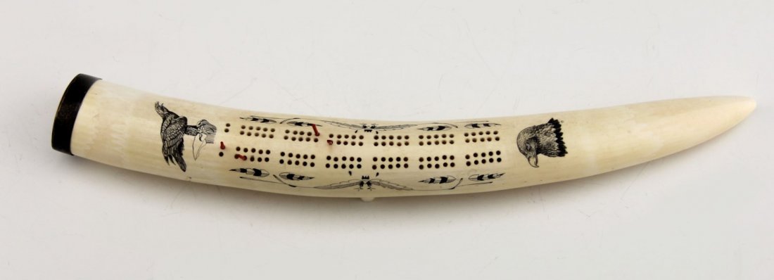 WALRUS TUSK CRIBBAGE BOARD WITH SCRIMSHAW: WALRUS TUSK CRIBBAGE BOARD WITH SCRIMSHAW Walrus tusk cribbage board with eagle and feather scrimshaw details and a silverplate cap. Four pins included. Weight: 722.5g Size: 15.5"