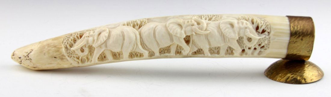 WALRUS TUSK WITH ELEPHANT IMAGERY: WALRUS TUSK WITH ELEPHANT IMAGERY Walrus tusk with elephant imagery, capped with a hammer finish brass stand. Weight: 602.4g Size: 13"
