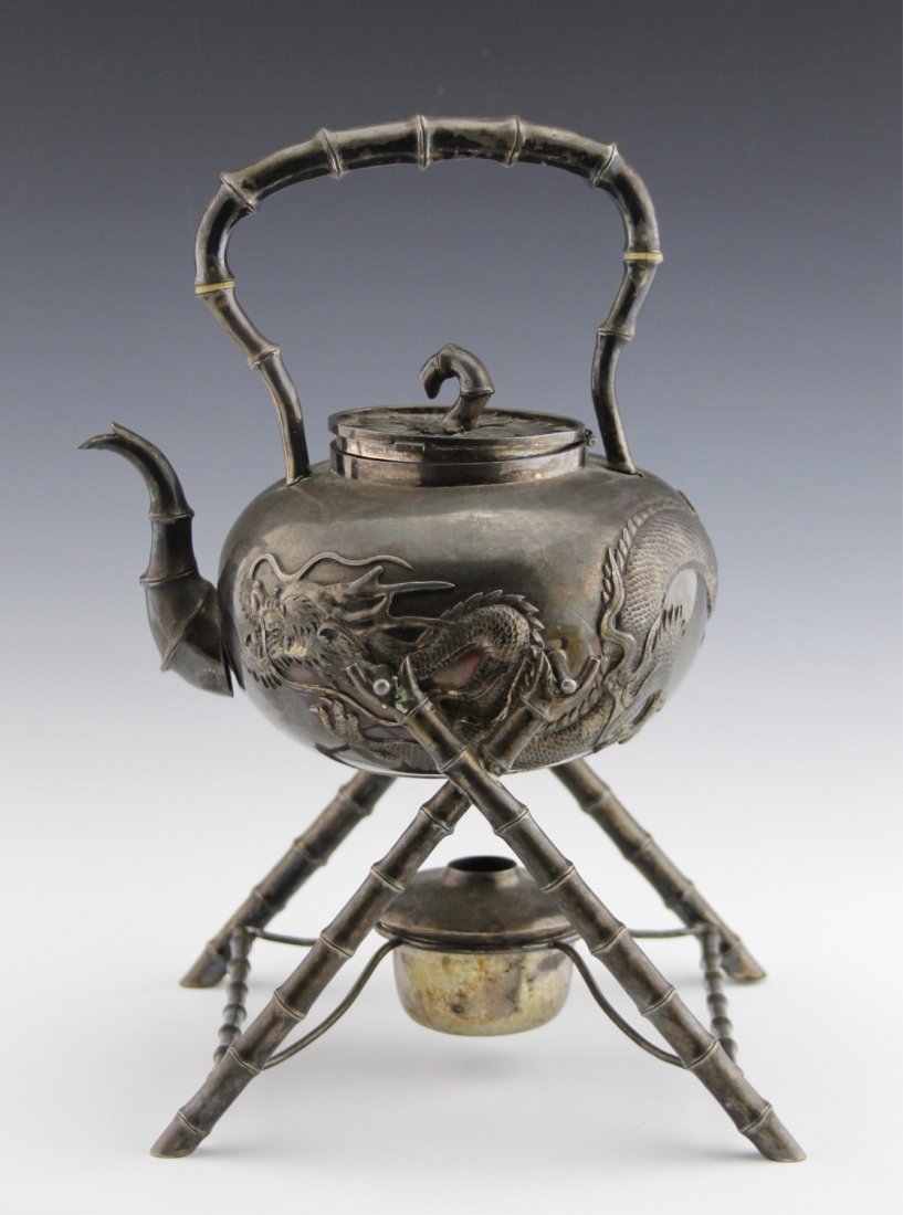 CHINESE 19TH C. WANG HING SILVER TEAPOT W STAND: CHINESE 19TH C. WANG HING SILVER TEAPOT W STAND Antique late 19th C. Chinese export silver tea pot with stand, stamped with Wang Hing hallmark on underside. Teapot depicts detailed dragon relief with 