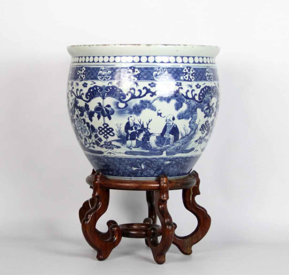 CHINESE BLUE & WHITE PORCELAIN PLANTER WITH STAND: CHINESE BLUE & WHITE PORCELAIN PLANTER WITH STAND Chinese large blue and white porcelain pot/planter with wooden stand. Precious things motif. Size: 13" tall, 16" diameter
