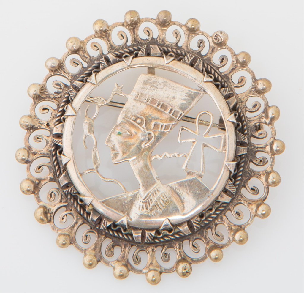 EGYPTIAN STERLING NEFERTITI PIN / PENDANT: EGYPTIAN STERLING NEFERTITI PIN / PENDANT Ladies pierced sterling pin/pendant, front design features profile portrait of Nefertiti with ankh symbol. Can be worn as a pin or a pendant. Weight: 13.7g Si
