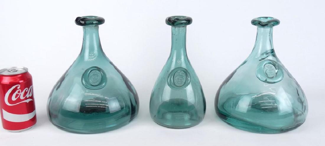 Holmegaard Cherry Elsinore Bottles: Lot (3) C. 1950's Danish Modern Holmegaard Cherry Elsinore bottles with applied tops and seals. Designed by Ole Winther in 1955. 9" Ht..