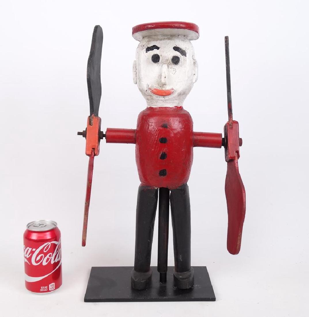 Folk Art Whirligig: Folk art polychrome painted wooden whirligig. Stand included. 18 1/2" Ht..