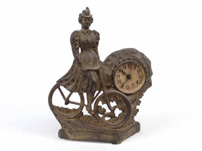 C. 1900 Bicycle Clock: C. 1900 bicycle clock. Female with safety bicycle. 11 1/2" Ht.. Good condition. Missing glass. To Benefit The Columbia Greene Humane Society.