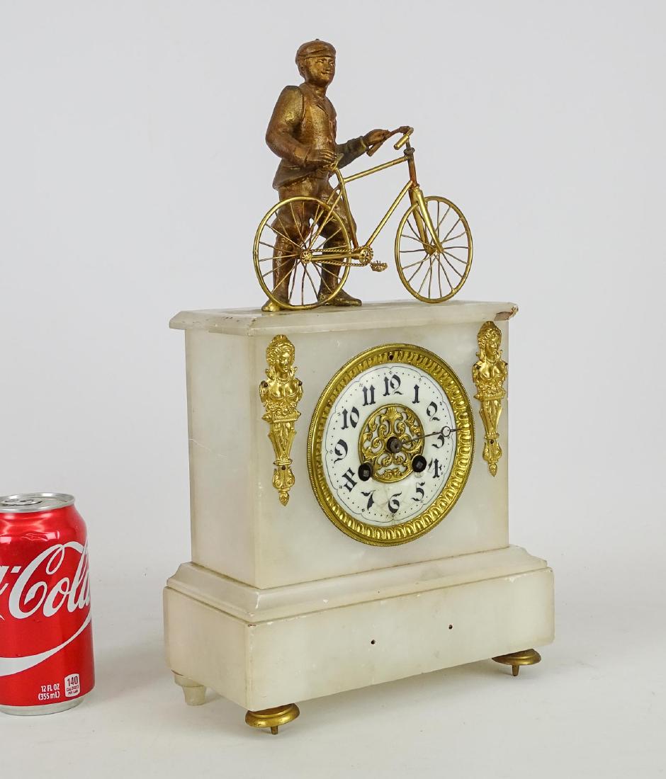 French Bicycle Clock: Early French marble bicycle clock. Top has man posed with safety bicycle. Case has imperfections. 9" x 4 1/2" x 15 1/2" Ht..