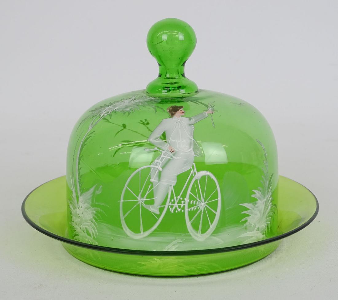 Mary Gregory Butter Dish: Mary Gregory green glass butter dish. Features figure on safety bicycle. 7" D., 5 1/2" Ht.. Good condition.