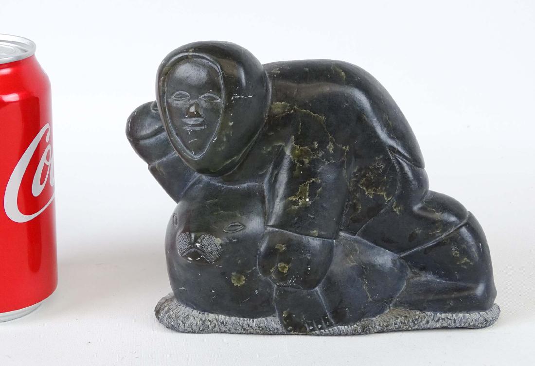 Inuit Stone Carving: Inuit stone carving. Eskimo with seal. Marked underside "77 / No 5 / 46202...". 6" W., 5 1/2" Ht..