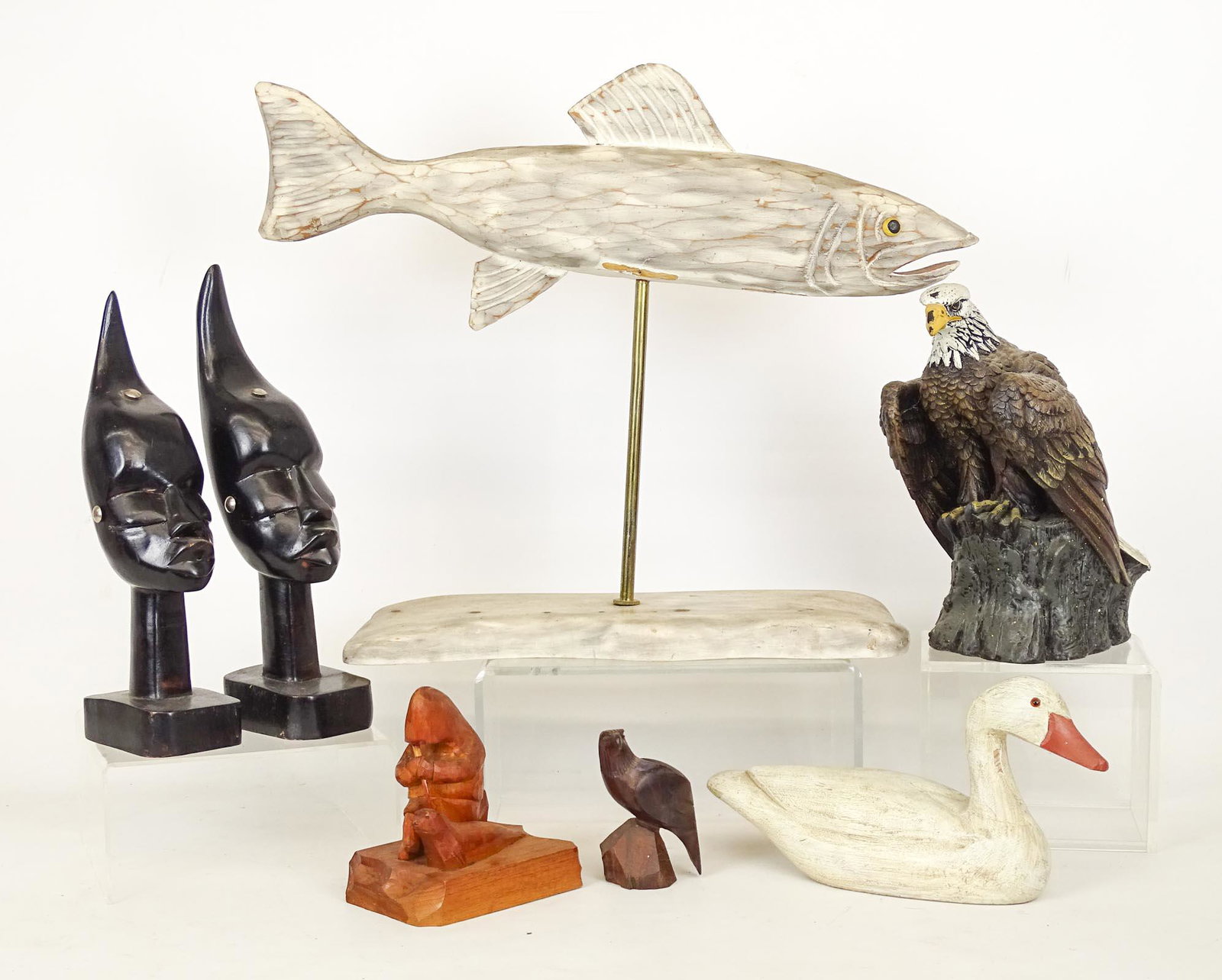 Misc. Lot: Misc. lot (7) items including carved fish (19 1/2" x 15 1/2"), (2) African carved heads, composition eagle, Quebec Inuit carving, carved wooden eagle, carved wooden duck.
