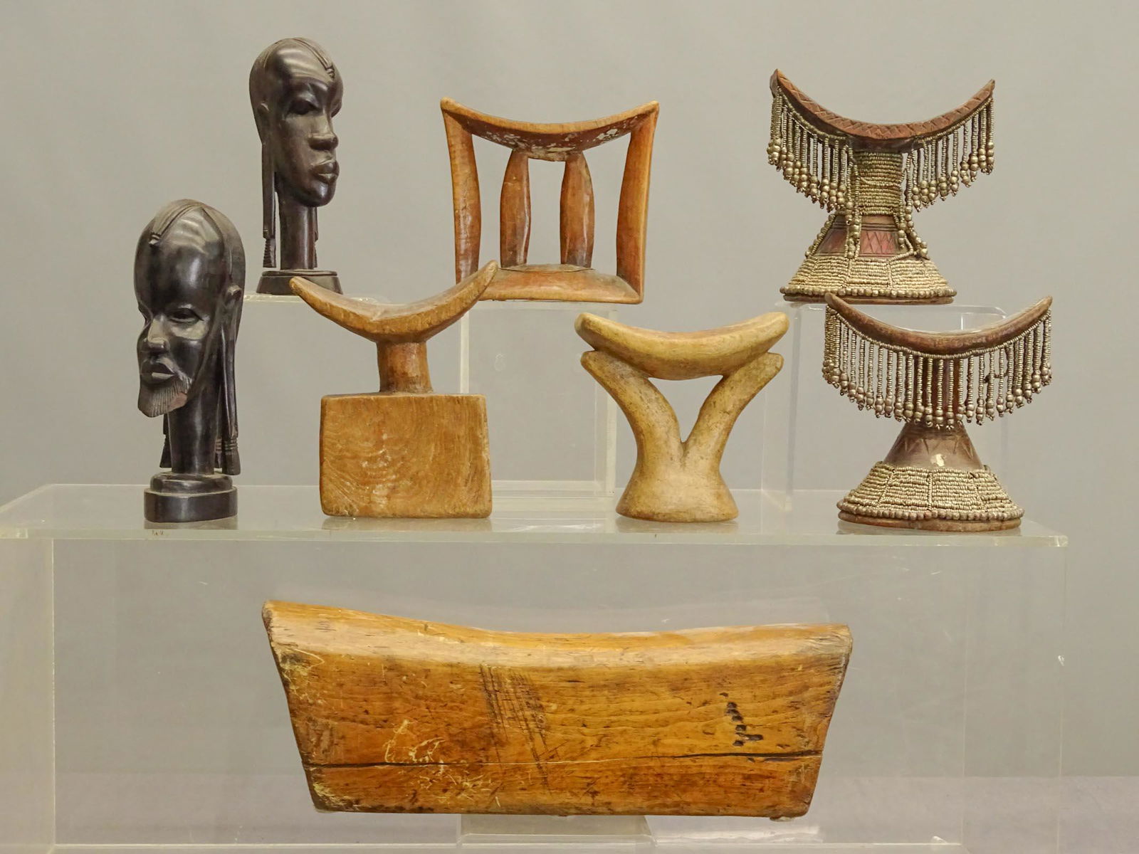 African Head Rests: Group of (6) African wooden head rests and (2) ebony carved heads.