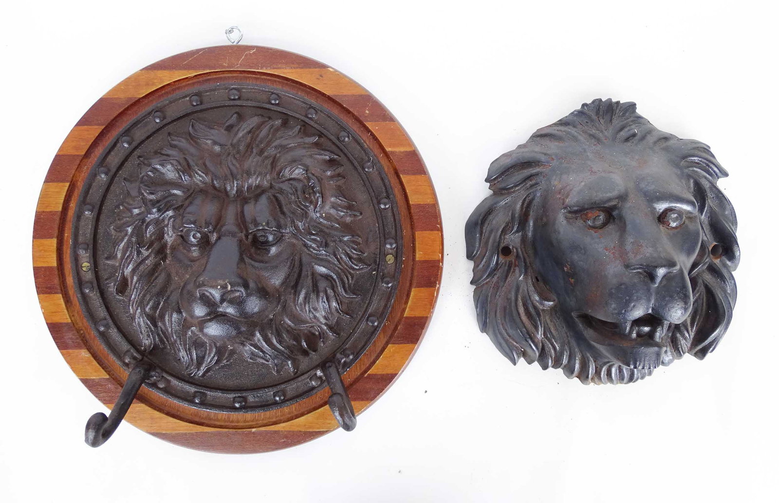 Cast Iron Lion Faces: Lot (2) cast iron lion faces. One mounted to board with hooks. 15" D., 10" x 10".