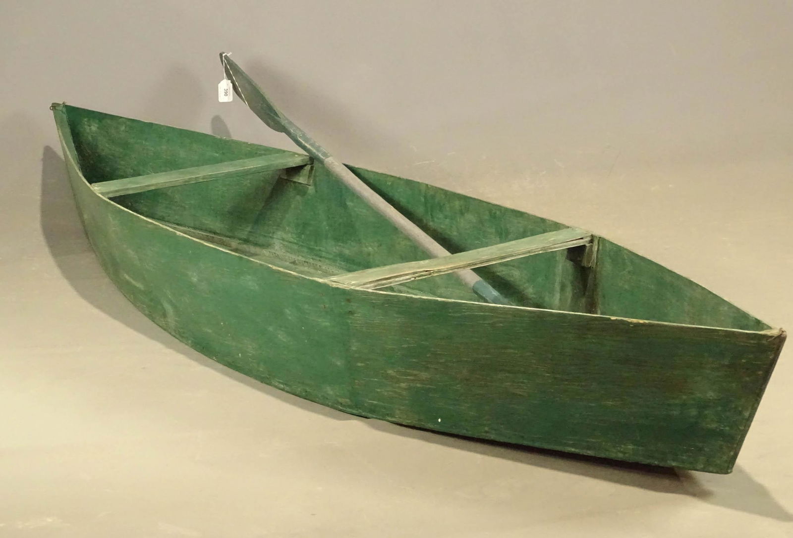 Early Trapper Boat: Early wooden trapper boat in green paint. 10' 7" L., 29" W., 12" Ht.. Comes with one oar.
